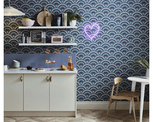 Kuchynská scéna so vzorovanými tapetami, kuchynskými skrinkami a dekoratívnymi doplnkami na policiach.