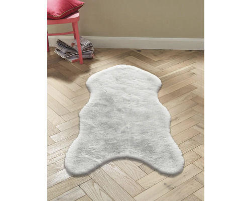 Biely koberec na drevenej podlahe