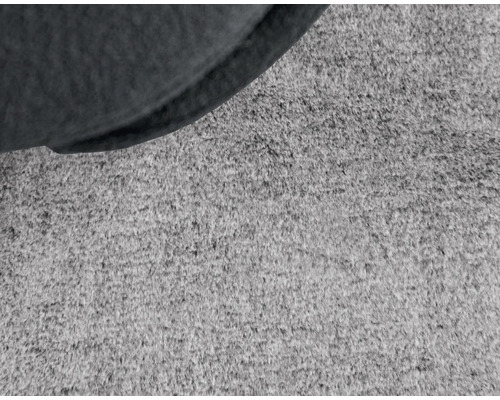 Detailný záber koberca s časťou sedacieho nábytku.