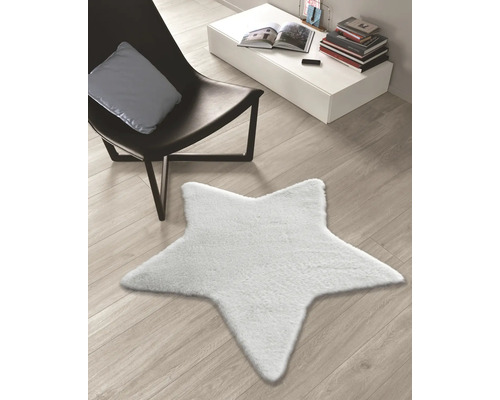 Koberec v tvare hviezdy na drevenej podlahe vedľa kresla a stola