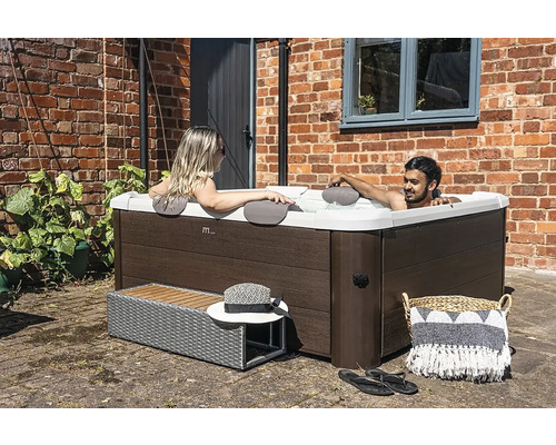 Pohľad zhora na vonkajšiu vírivku s dvoma relaxujúcimi ľuďmi