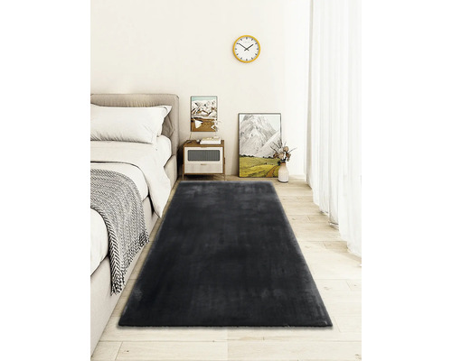 Spálňa s posteľou, nočným stolíkom a tmavosivým kobercom