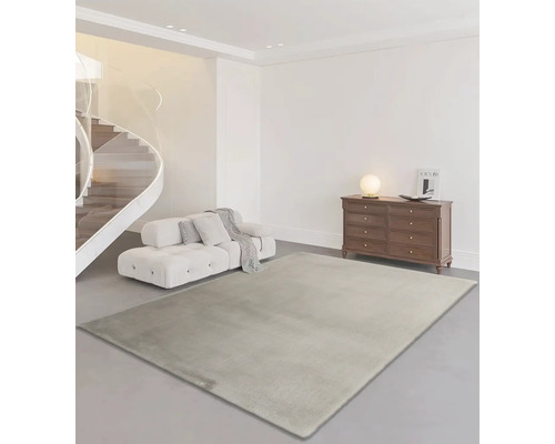 Obývacia izba s kobercom, pohovkou, komodou a točitým schodiskom