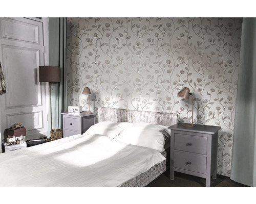 Spálňa s posteľou, nočnými stolíkmi a kvetinovou tapetou