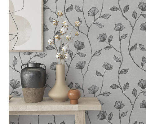 Nástenná dekorácia s kvetinovou tapetou a ozdobnými vázami na stole.