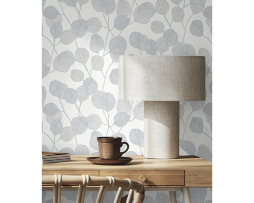 Scéna s modrou tapetou s listami, stolnou lampou a písacím stolom