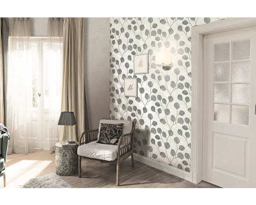 Obývacia izba s tapetou s listovými motívmi, kreslom a dverami