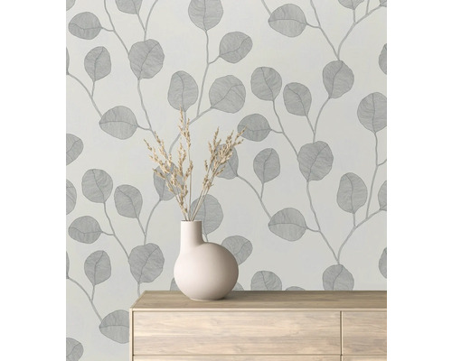 Tapeta so vzorom listov v miestnosti s vázou na komode.