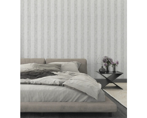 Spálňa s posteľou, nočným stolíkom a pruhovanou tapetou