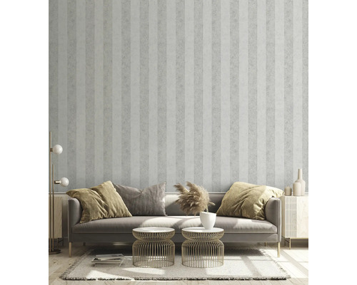 Obývacia izba s pruhovanou tapetou, pohovkou, príručnými stolíkmi a dekoratívnymi prvkami pre štýlové prostredie.