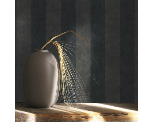 Dekoratívna váza s obilným klasom na drevenom stole pred pruhovanou tapetou