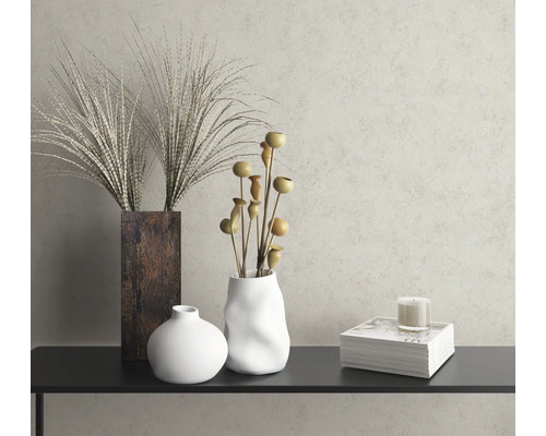 Dekoratívne zátišie s vázami, rastlinami a sviečkou na poličke