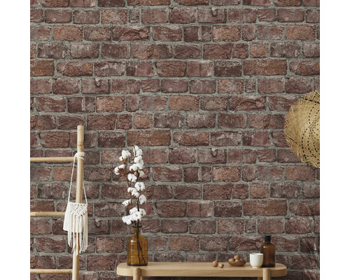 Stena s tapetou imitujúcou tehly a dekoratívnymi prvkami ako rebrík, taška, klobúk, váza a stôl