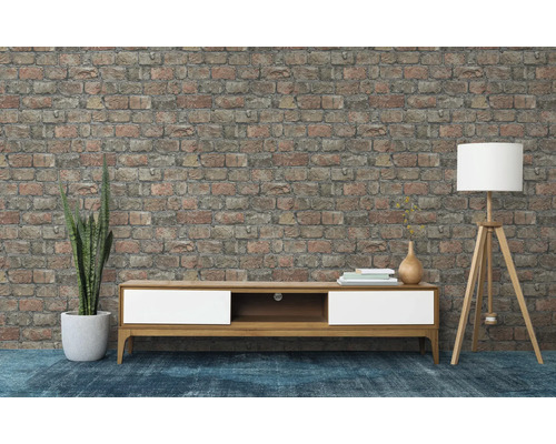 Obývacia izba s nízkou skrinkou, stojacou lampou a tehlovou stenou