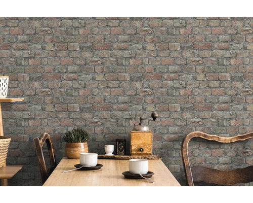 Nástenná dekorácia s tehlovou tapetou v jedálni.
