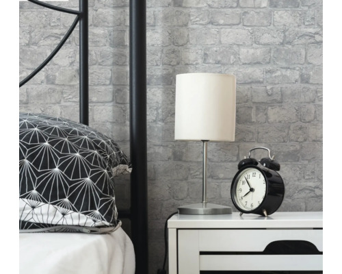 Spálňová scéna s posteľou, nočným stolíkom, lampou, budíkom a tapetou so stenami