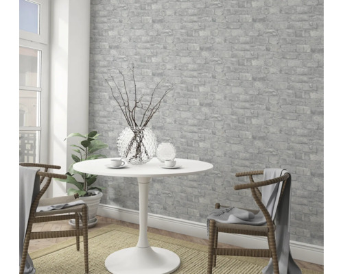 Svetlá izba s tapetou s motívom tehál, stolom a stoličkami