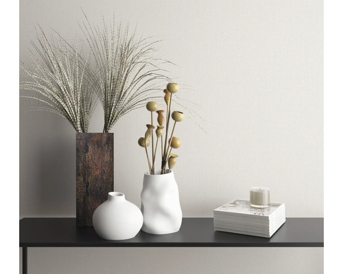 Dekoratívna scéna s vázami, sušenými kvetmi, sviečkou a knihou na konzole