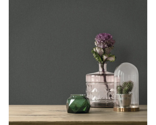 Dekoratívne doplnky na stole pred tmavou tapetou