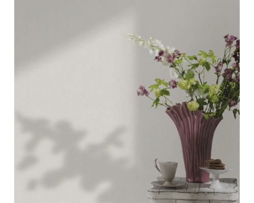 Zátišie s kvetmi, vázou, šálkou a pečivom na stole