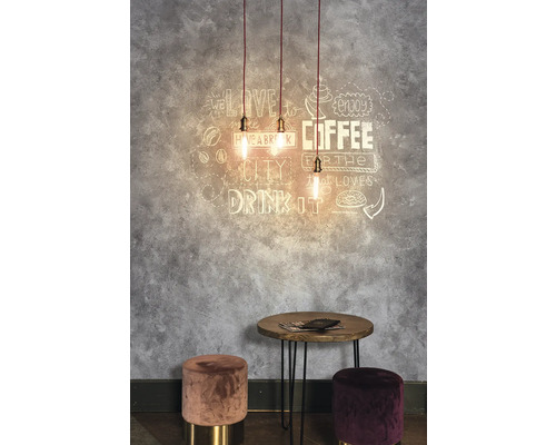 Dekoratívny priestor so závesnými svietidlami, nástenným umením, stolom a stoličkami.