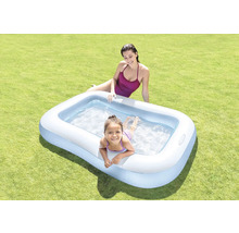 Nafukovací bazén s dvoma ľuďmi na trávniku.