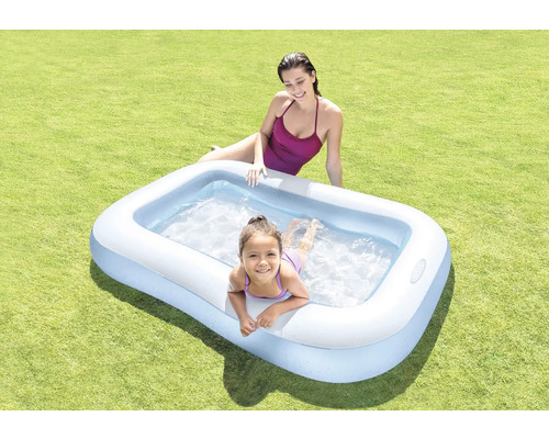 Nafukovací bazén s dvoma ľuďmi na trávniku.
