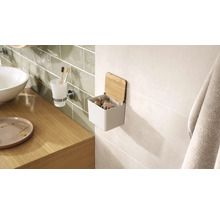 Interiér kúpeľne s umývadlom, pohárom na zubné kefky a nástenným úložným boxom s bambusovým vekom