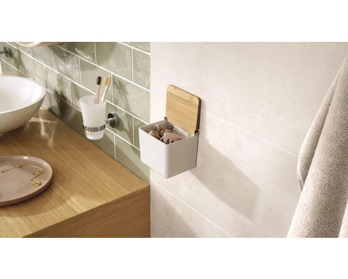 Interiér kúpeľne s umývadlom, pohárom na zubné kefky a nástenným úložným boxom s bambusovým vekom