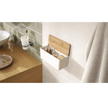 Kúpeľňová scéna s umývadlom, držiakom na pohár na zubné kefky a nástennou policou s bambusovým vekom na uloženie kúpeľňových potrieb.