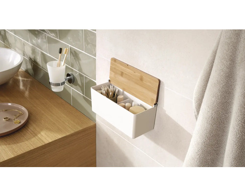 Kúpeľňová scéna s umývadlom, držiakom na pohár na zubné kefky a nástennou policou s bambusovým vekom na uloženie kúpeľňových potrieb.