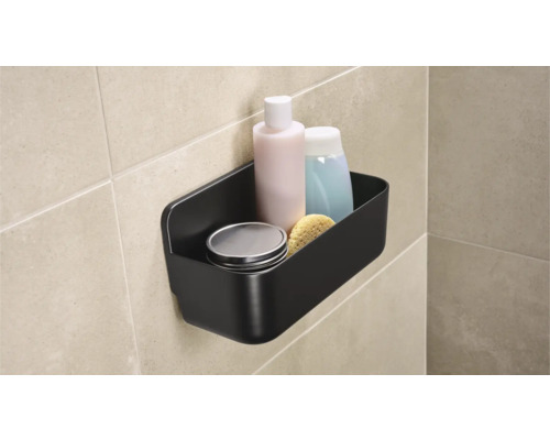 Čierna kúpeľňová polica s toaletnými potrebami na stene