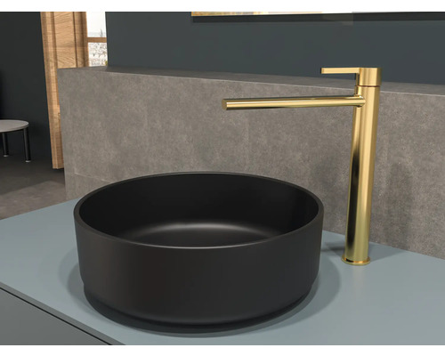 Čierne umývadlo na dosku so zlatou batériou na poličke