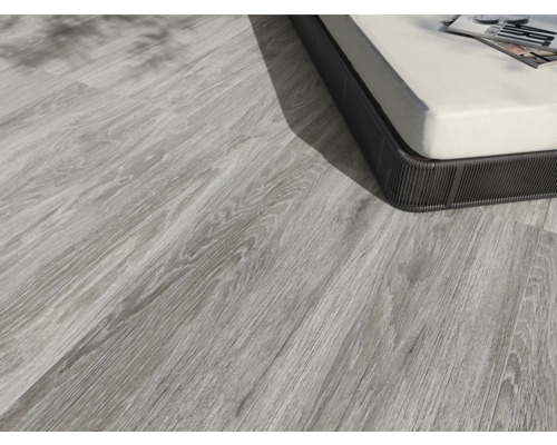 Svetlá drevená podlaha vedľa kusu nábytku