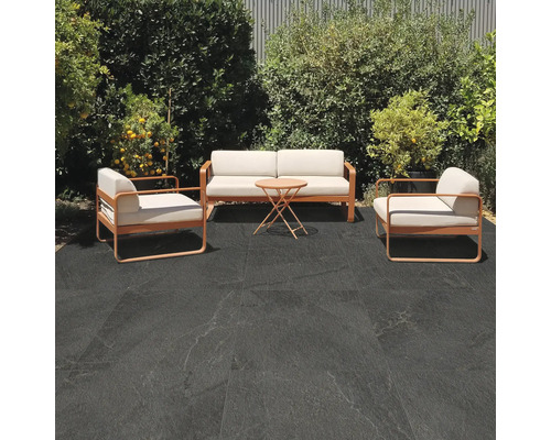 Terasa s posedením a tmavými podlahovými dlaždicami vo vonkajšom priestore.