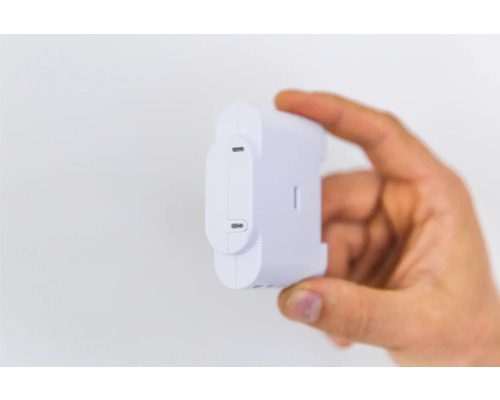 Ruka drží biely snímač energie Shelly