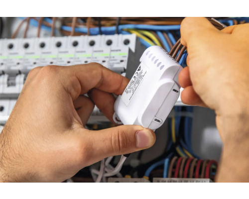 Elektrikár montuje rozdeľovač do rozvádzača