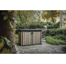 Záhradná skriňa na náradie s dreveným efektom a žena v pozadí v záhradnej krajine