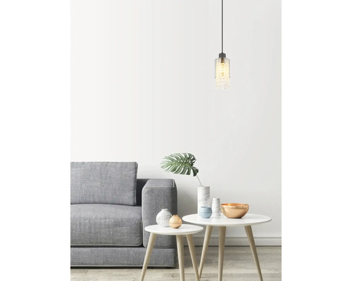 Svetlý interiér so sivou pohovkou, bielymi stolíkmi a dekoratívnym závesným svietidlom