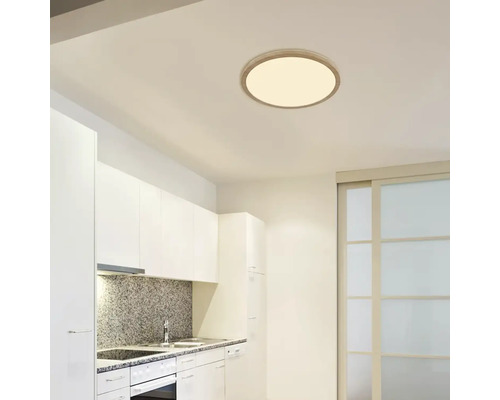 Moderná kuchyňa s okrúhlym stropným svietidlom pre svetlé a priateľské prostredie.