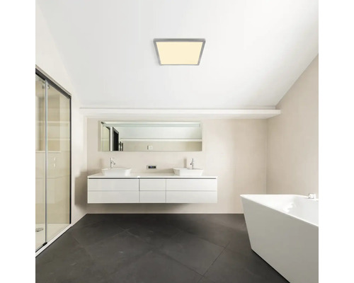 Moderná kúpeľňa so štvorcovým stropným svietidlom, umývadlami a vaňou