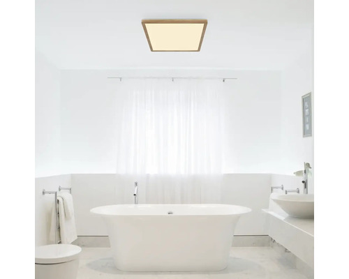 Moderná kúpeľňa s voľne stojacou vaňou a štvorcovým stropným svietidlom s dreveným rámom