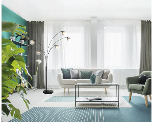 Obývacia izba s pohovkou, kreslom, kobercom, stolom a oblúkovou lampou