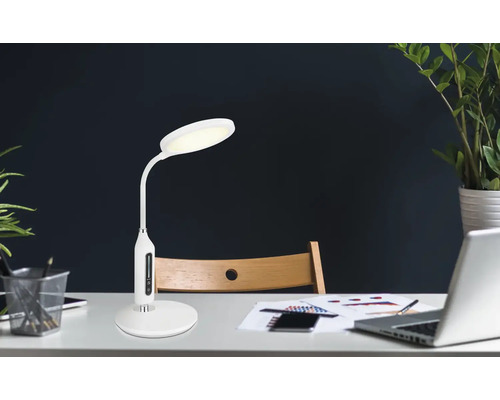 Písací stôl so stolnou lampou, notebookom a kancelárskymi potrebami