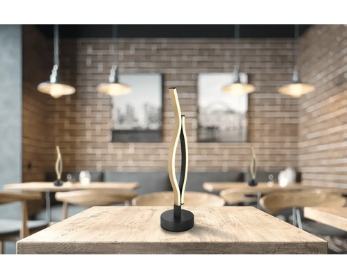Dekoratívna stolná lampa z dreva a kovu na stole