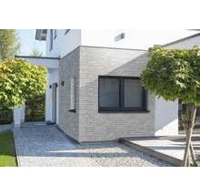 Fasáda domu s murovanou stenou a oknom