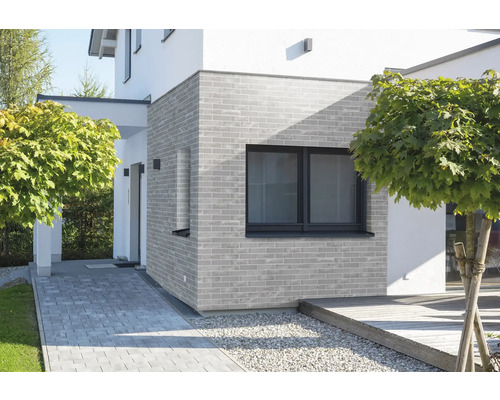 Fasáda domu s murovanou stenou a oknom