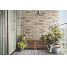 Balkón s kamennou stenou, drevenou podlahou a rastlinami