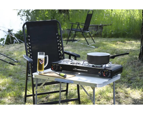 Vonkajšia scéna s kempingovým stolom, plynovým sporákom a stoličkou