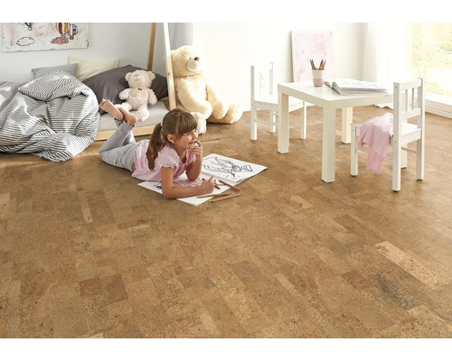 Svetlá detská izba s korkovou podlahou, detským nábytkom a hrajúcim sa dievčaťom.